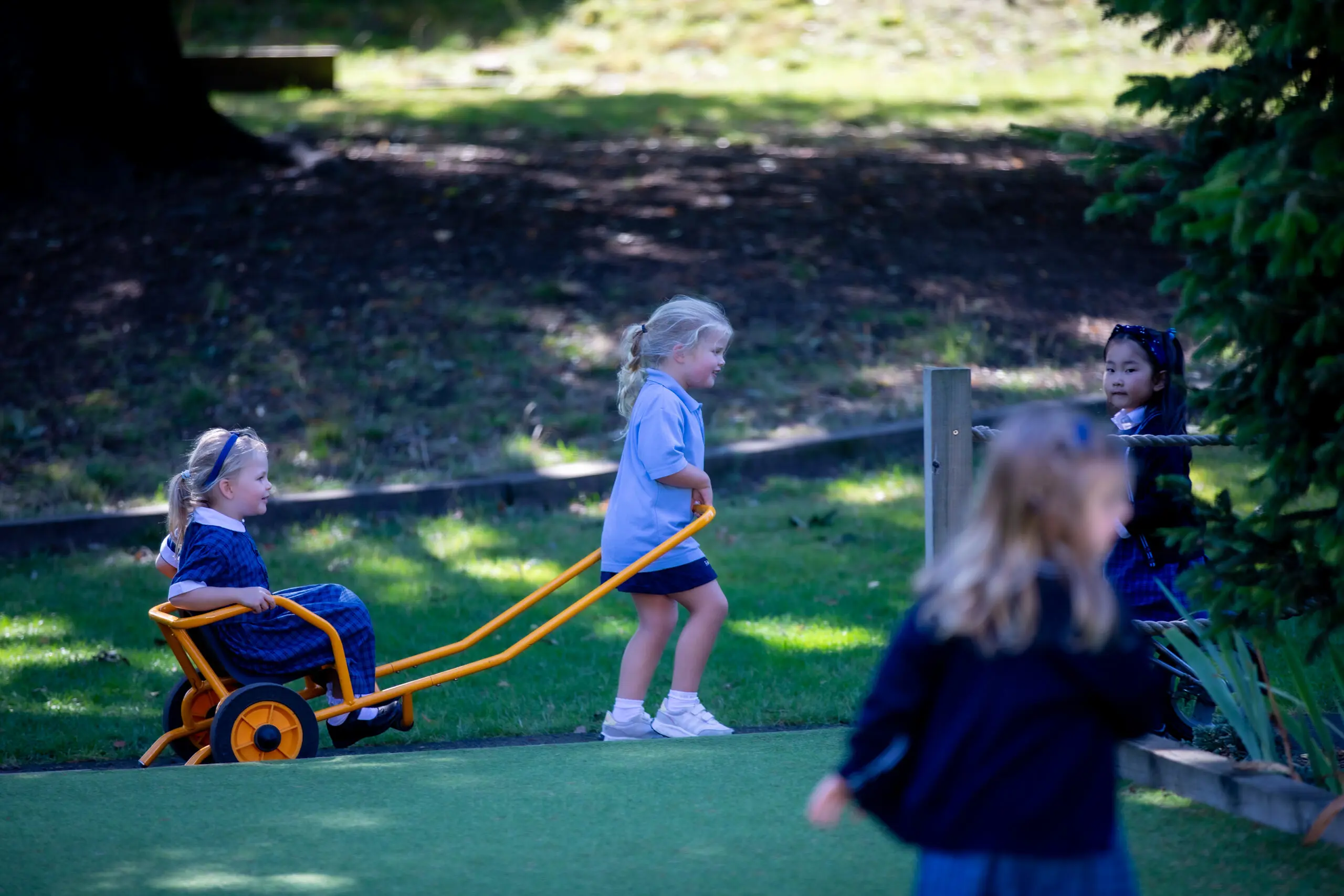 Student pulling classmate in cart