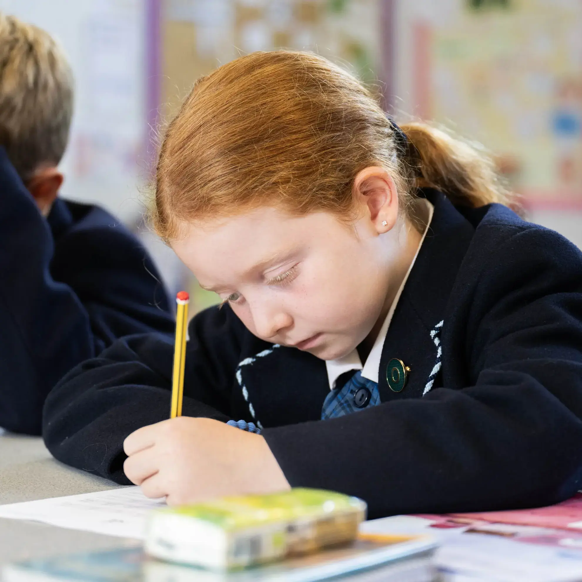 Student writing with a pencil