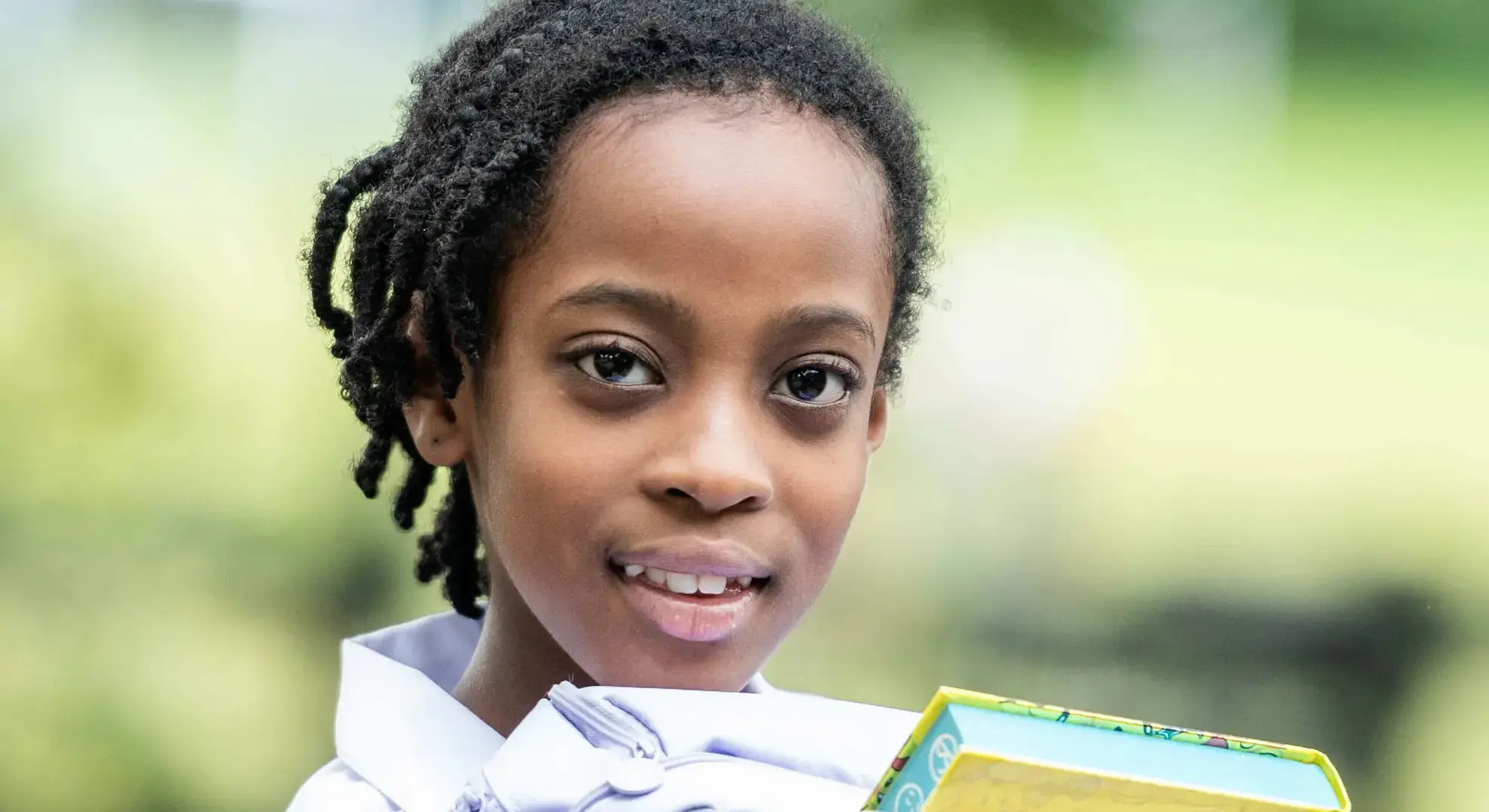 Gently smiling girl holding folders and books