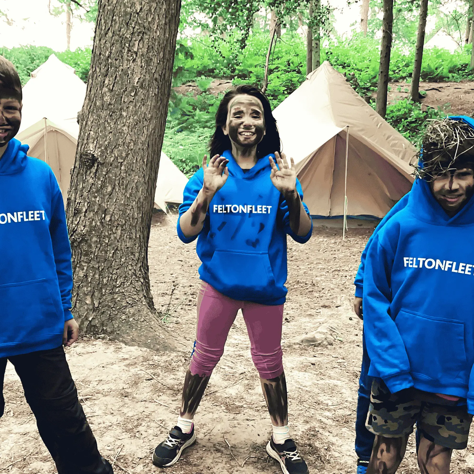Students on a residential, wearing facepaint in a wooded area