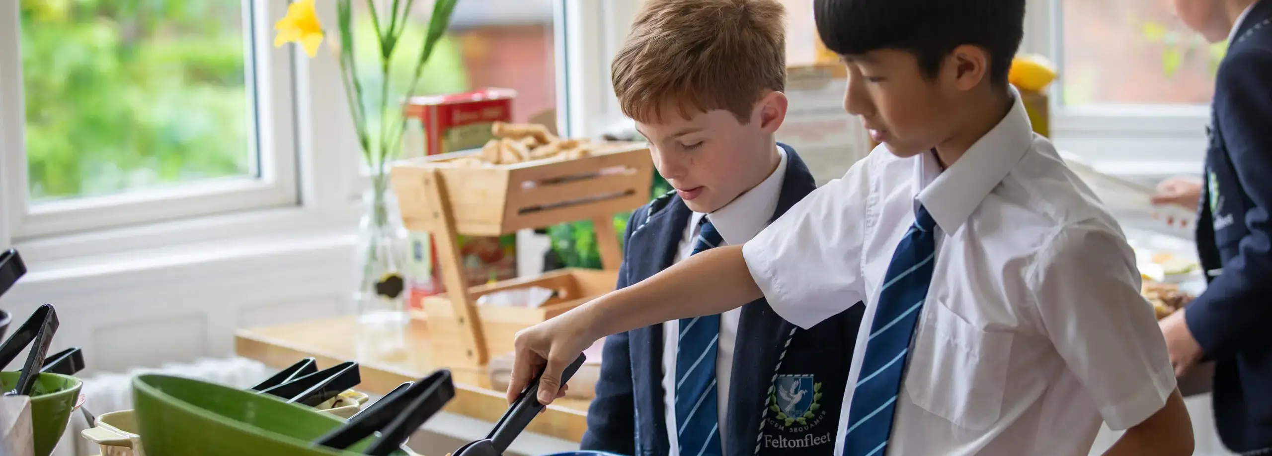 Students selecting sliced peppers to add to a lunch tray