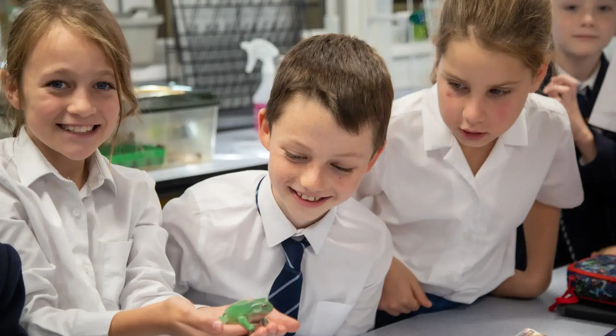 Students holding frog and smiling