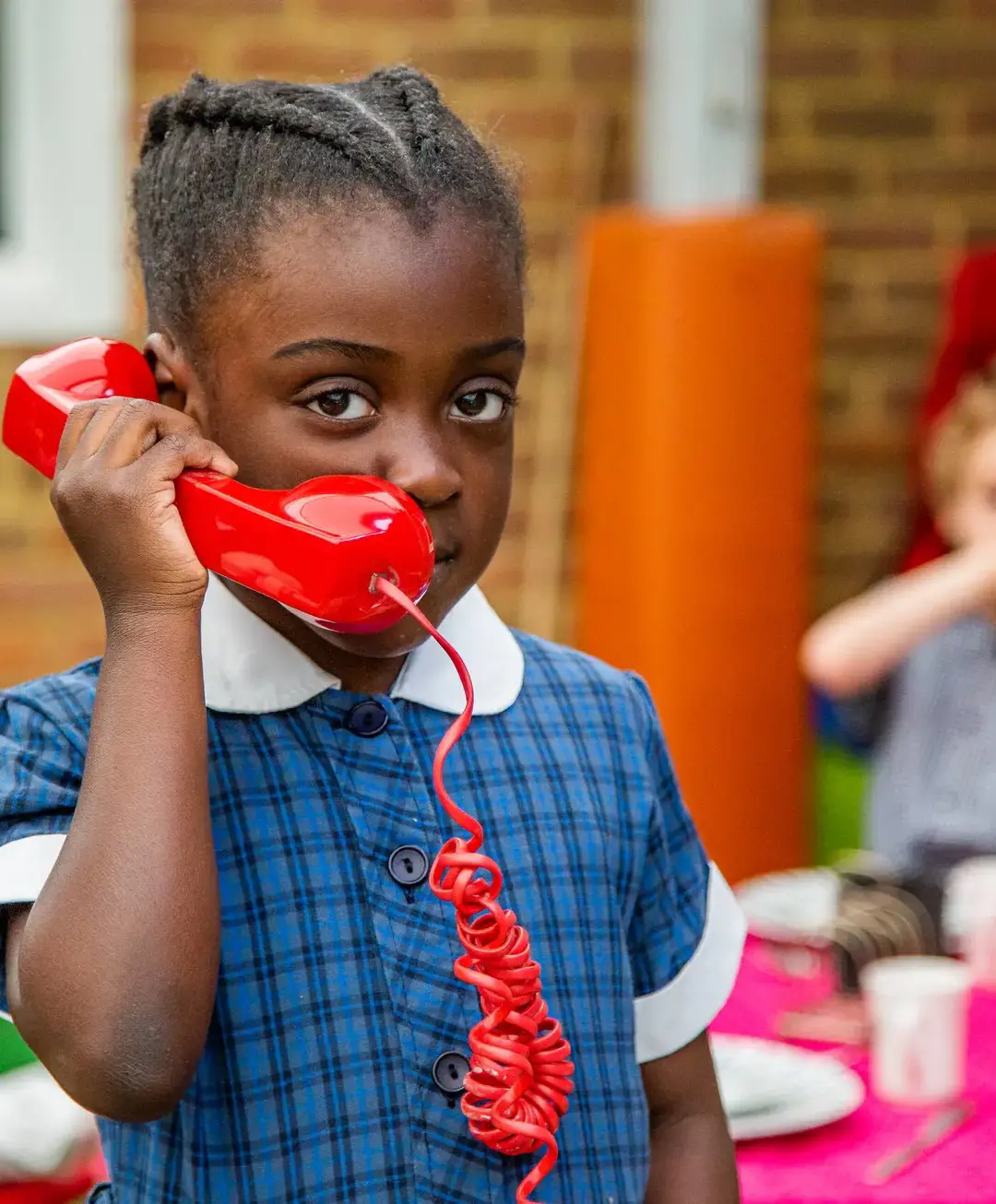 Student holding red phone to ear