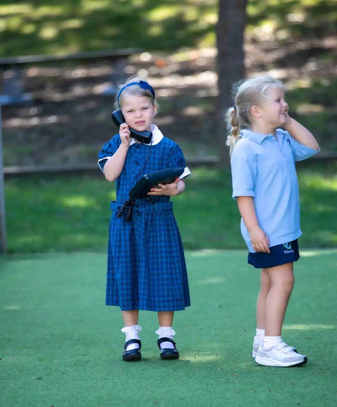 Students on playground role-playing phone conversation
