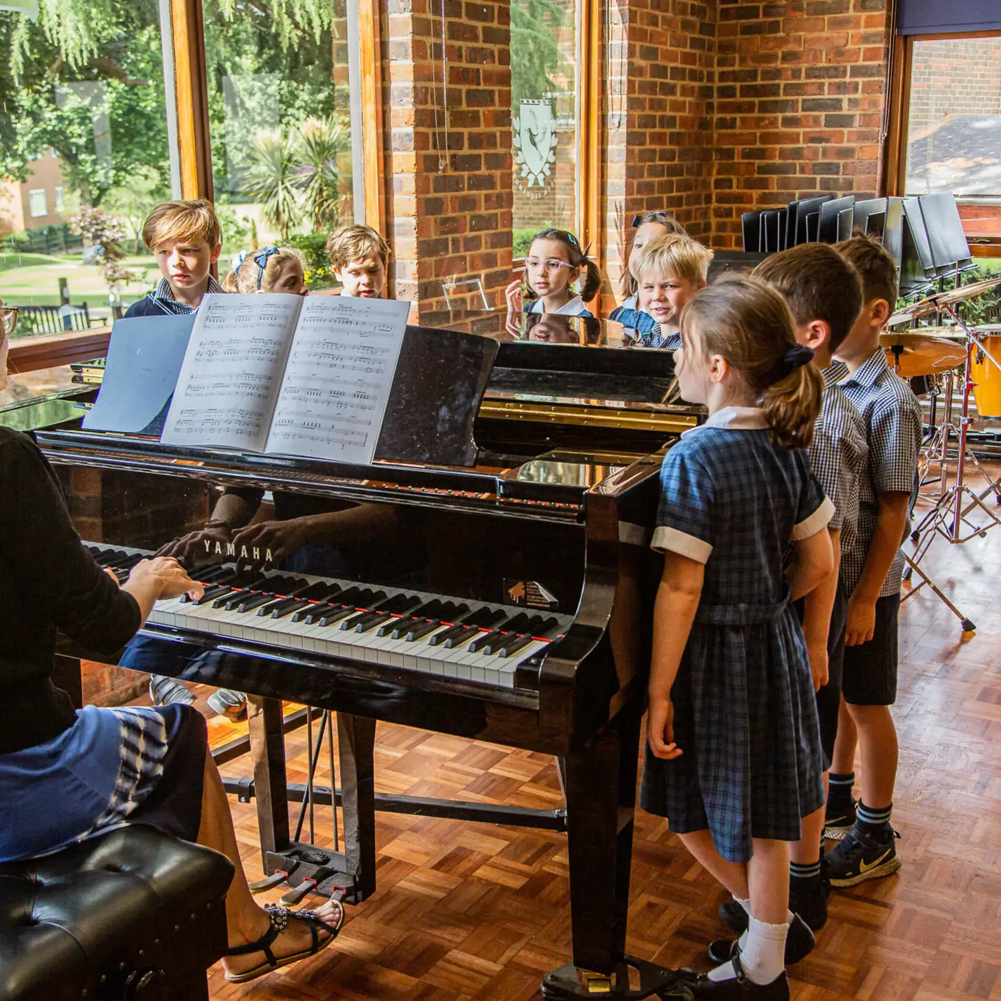 Students standing at piano