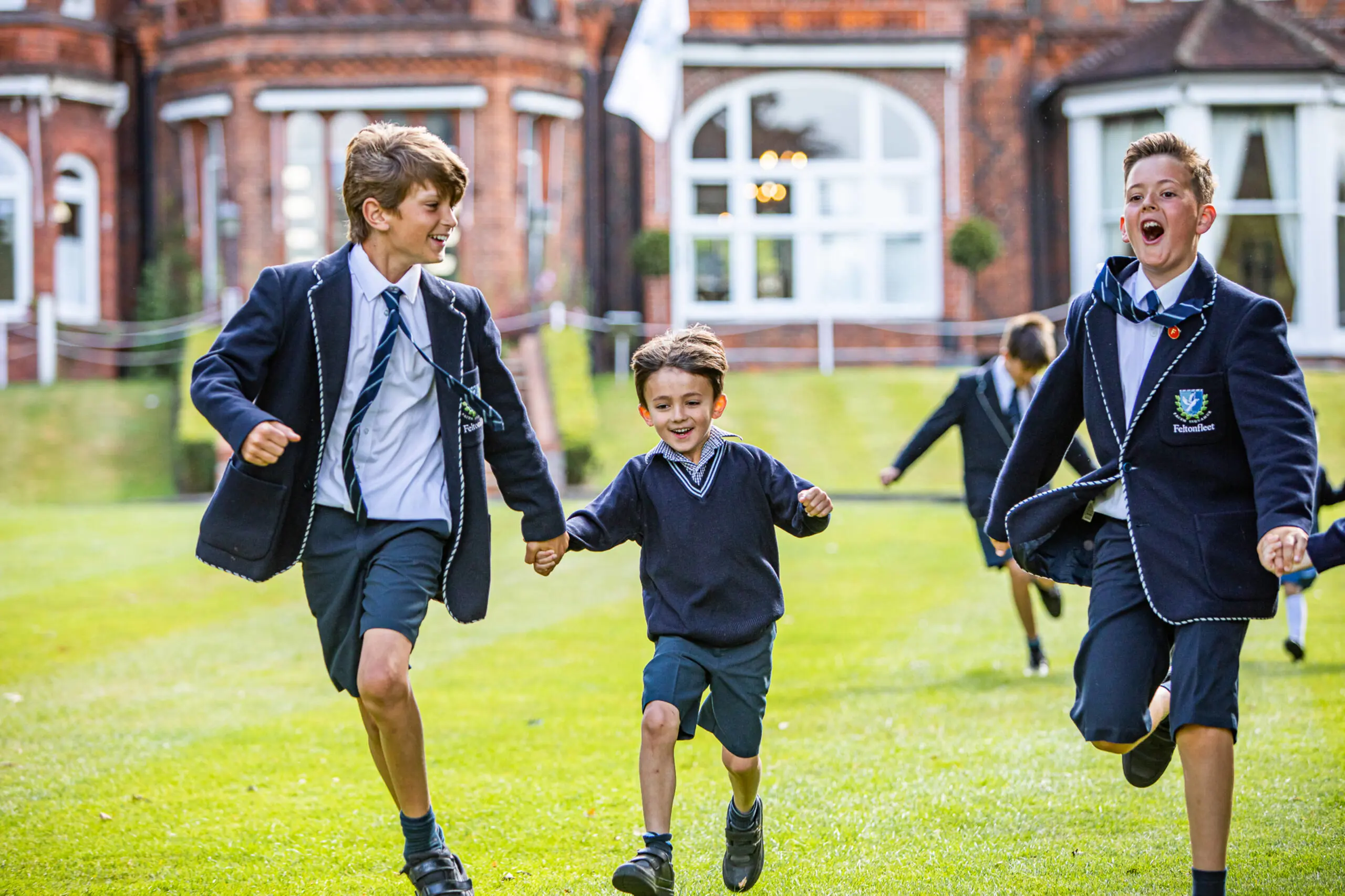 Two older students running with a younger student