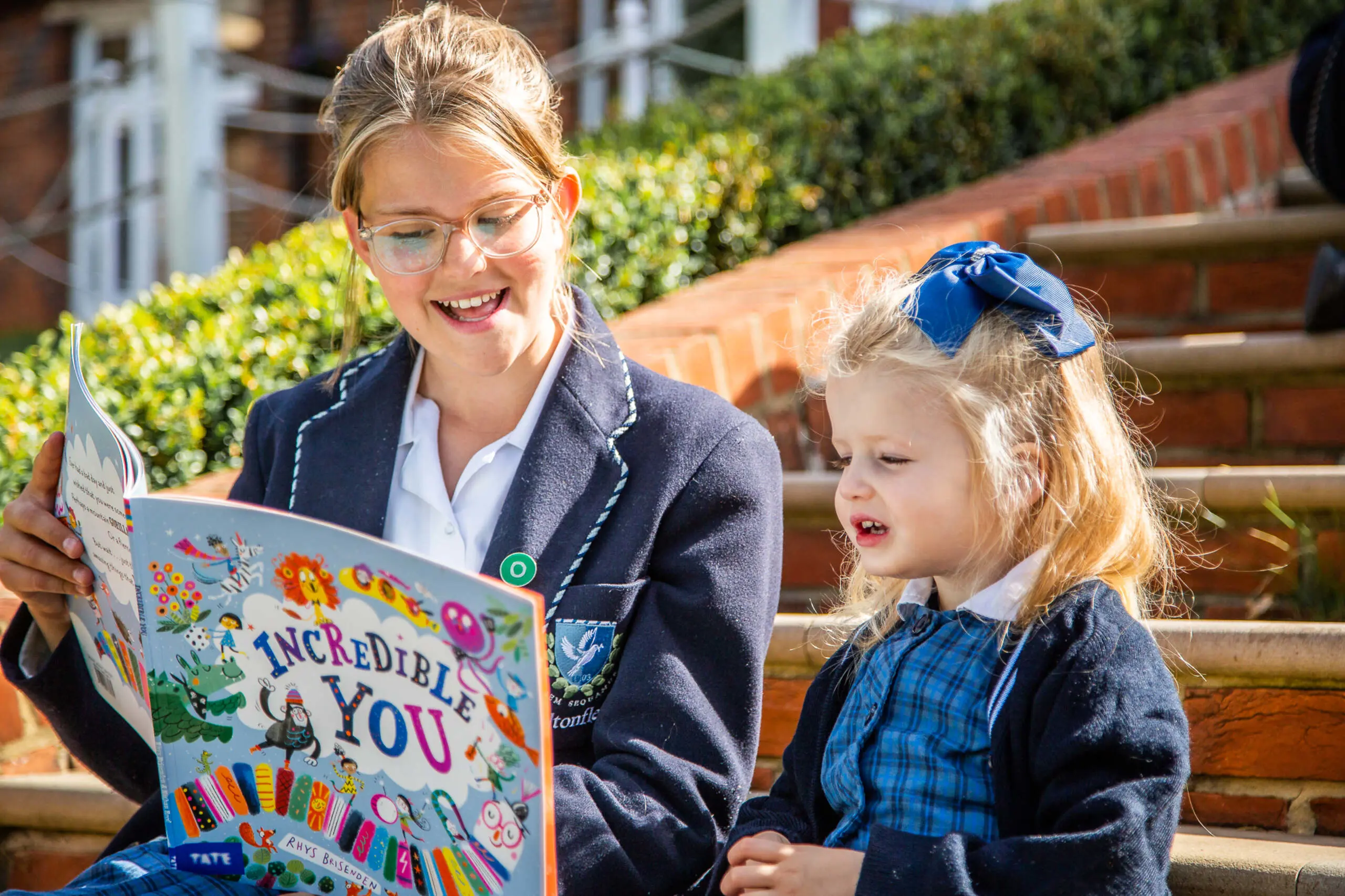 Student reading to younger child