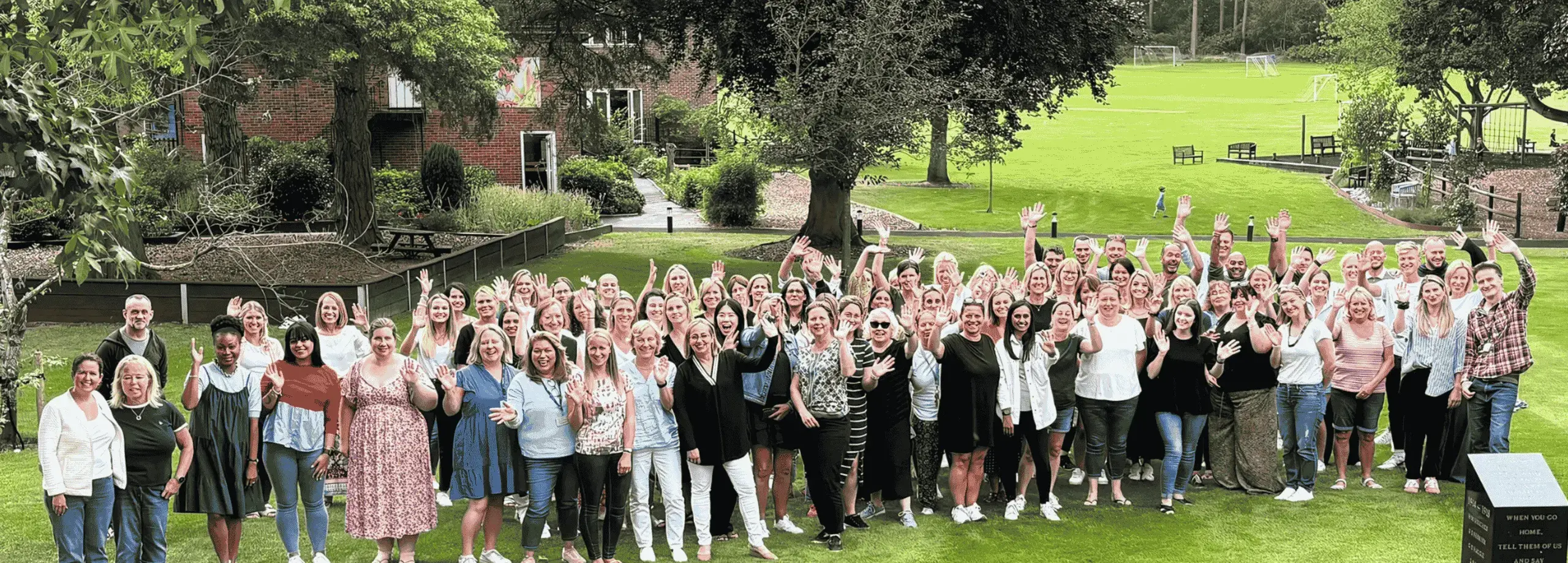 A group of staff wave up at the camera