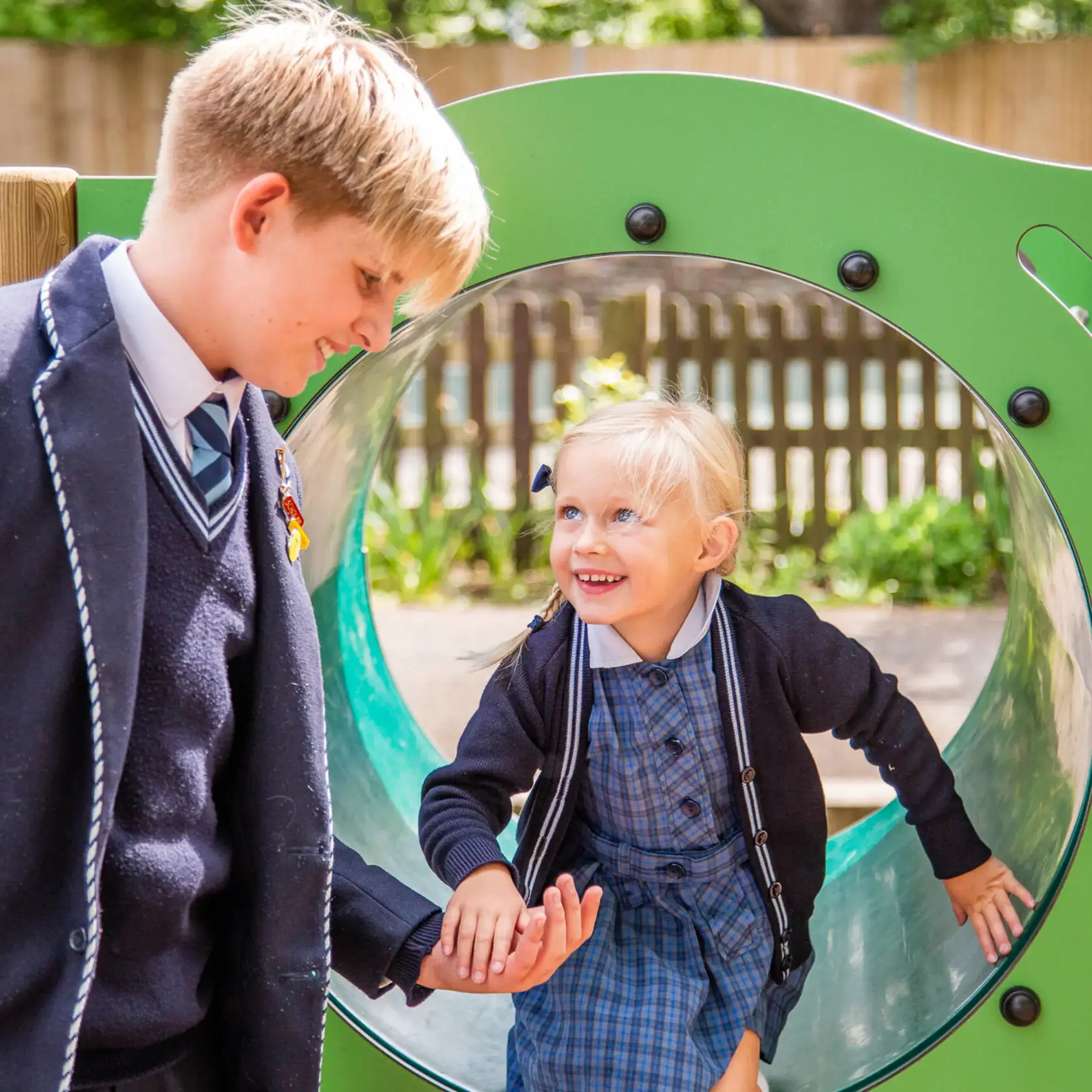Student offering an assisting hand to a younger peer