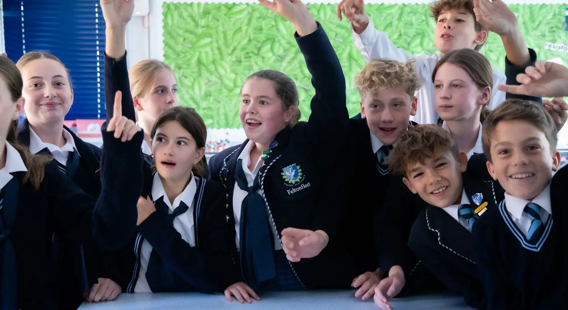 Students excitedly raising their hands in lesson