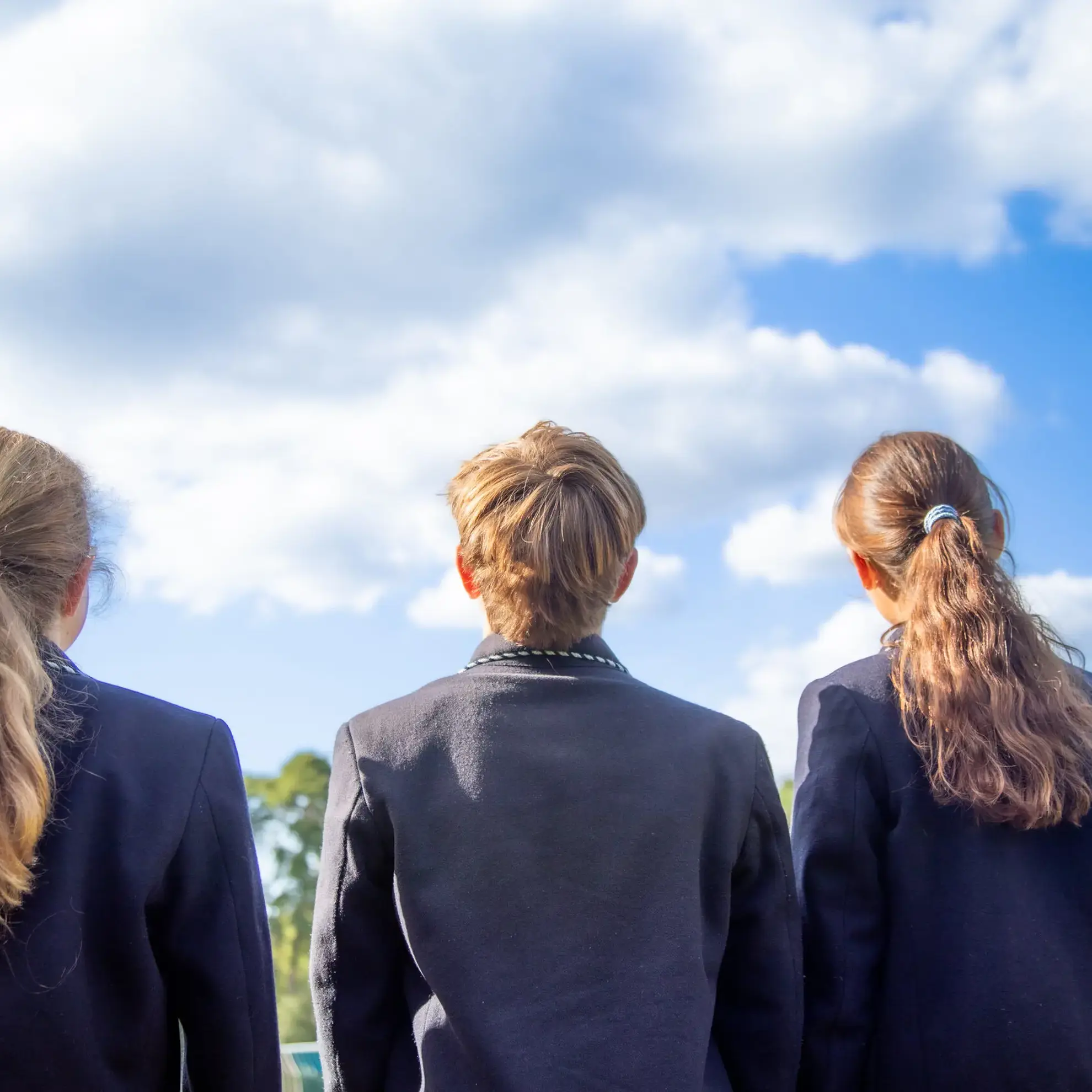 Students looking up at the sky, photographed from behind