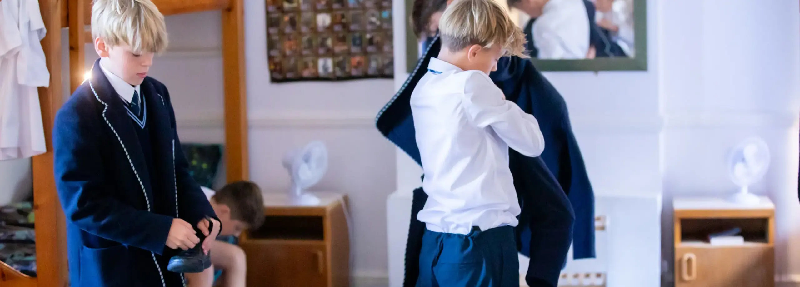 Boarding pupils of a mixed age range getting ready for the day ahead in their dorm room.